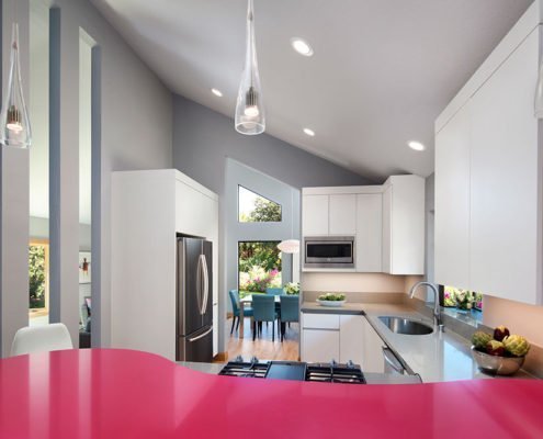 A sleek, modern kitchen in La Honda is accented by a magenta peninsula.