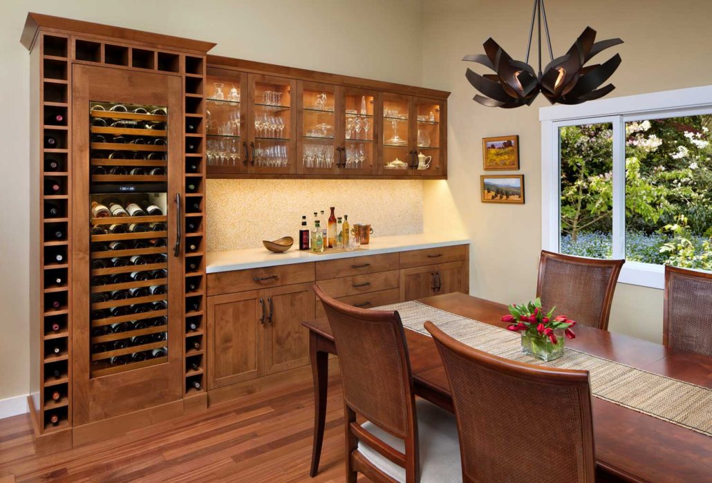 A dining room with a bar and wine storage.