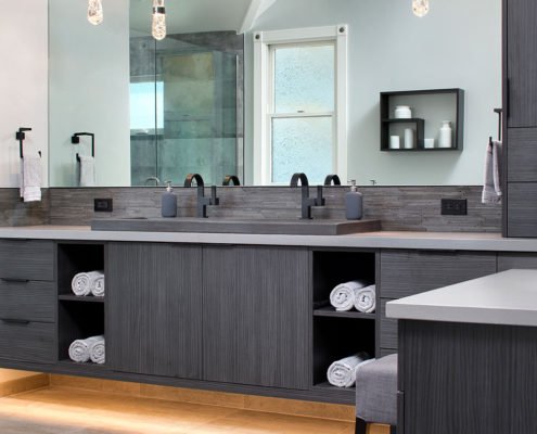 A spacious, modern, monochromatic bathroom in Willow Glen features an illuminated floating vanity.