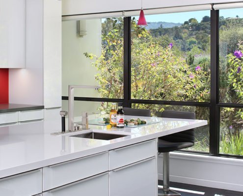 A sleek kitchen island features a second, smaller sink to prepare drinks in Los Altos Hills.