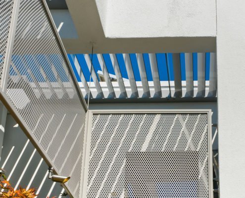 A modern Los Altos Hills home is shaded by mesh screens and metal louvers.