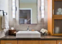 A contemporary bathroom with a vessel sink and plenty of storage.