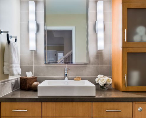 A contemporary bathroom with a vessel sink and plenty of storage.