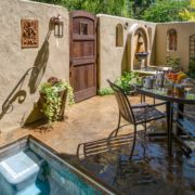 Enclosed patio with a spa, seating, and a small fountain