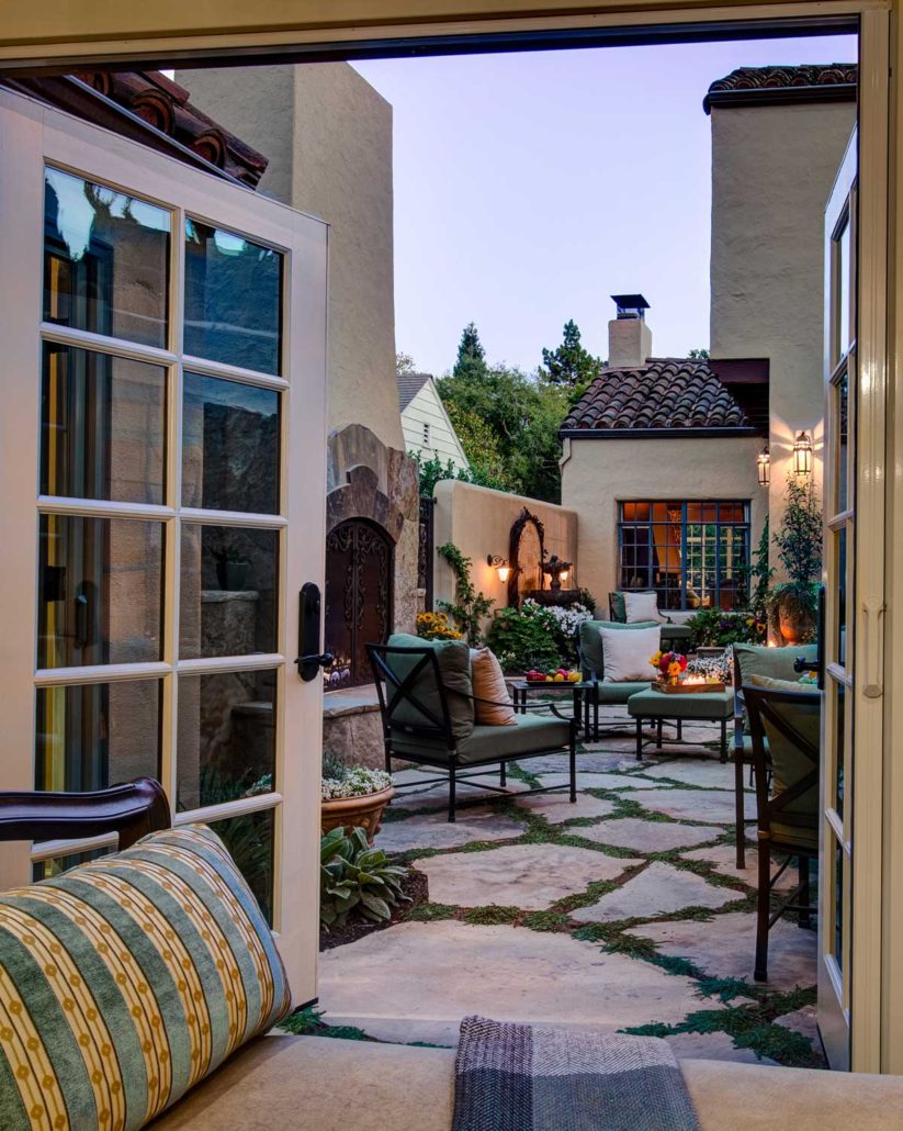 A Mediterranean-inspired patio in downtown Palo Alto features a fireplace, seating, and a fountain.