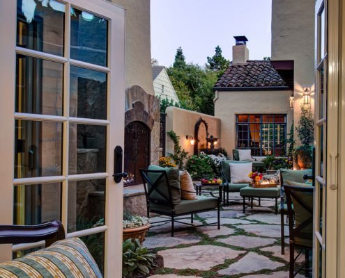 A Mediterranean-inspired patio in downtown Palo Alto features a fireplace, seating, and a fountain.