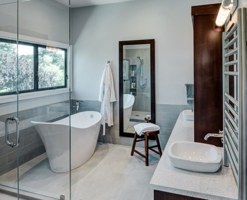 A spacious primary bathroom in Mountain View has a glass-enclosed shower and soaking tub.
