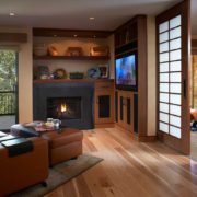 Black fireplace built into shelves next to a mounted TV