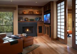 Black fireplace built into shelves next to a mounted TV