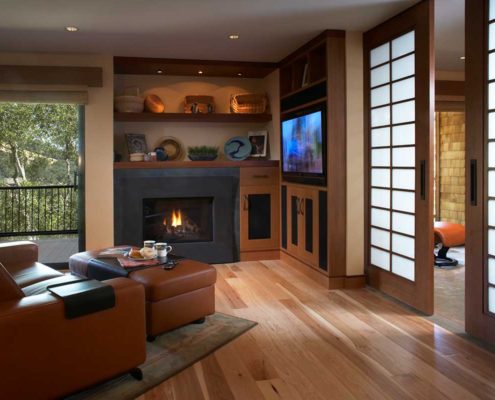 Black fireplace built into shelves next to a mounted TV