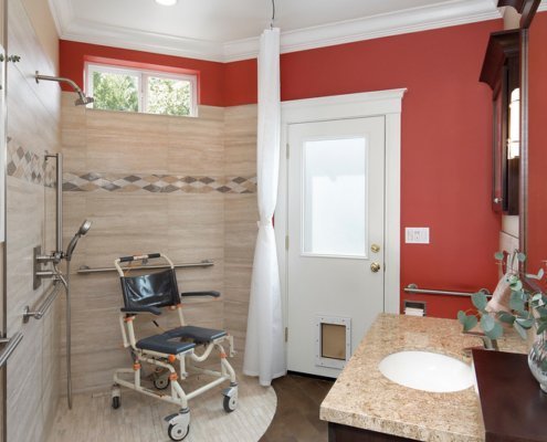 A universal design bathroom features a corner curbless shower with a shower wheelchair.
