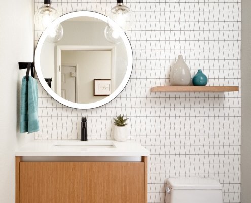 Bright white bathroom with wooden drawers and shelving