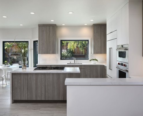 A sleek, neutral kitchen offers views of the backyard from the sink and breakfast nook.