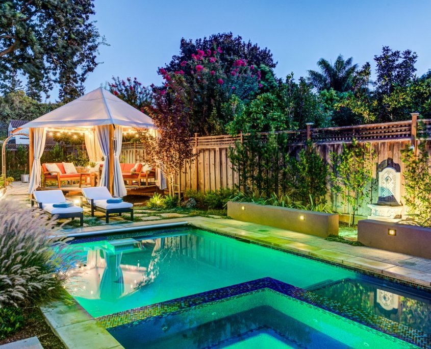 gazebo outdoor seating area next to lit pool