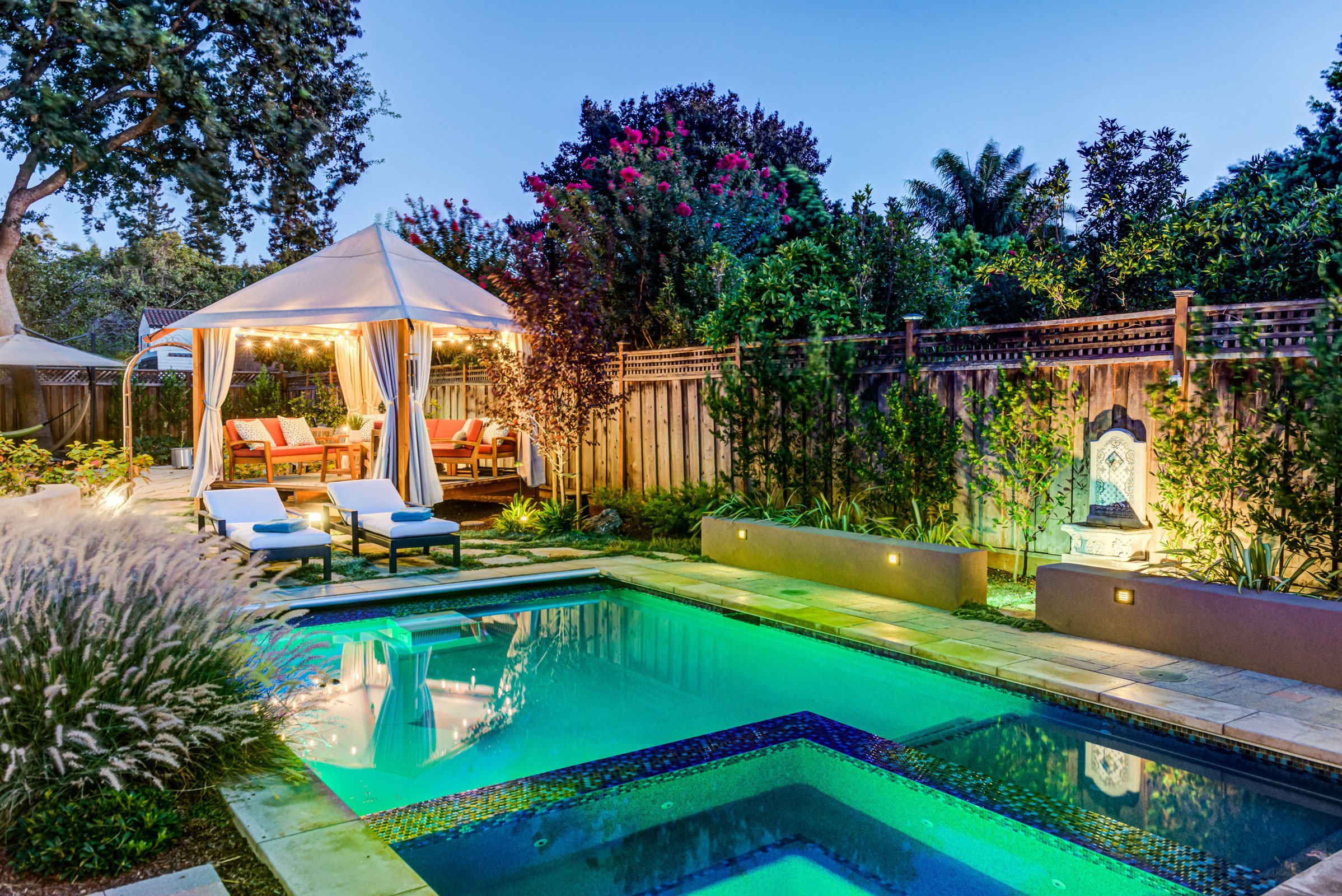 gazebo outdoor seating area next to lit pool