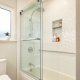 white bathroom and shower with shower shelves