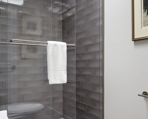 Sliding glass doors and glossy gray tiles give this Los Altos bathroom a sleek, modern feel.