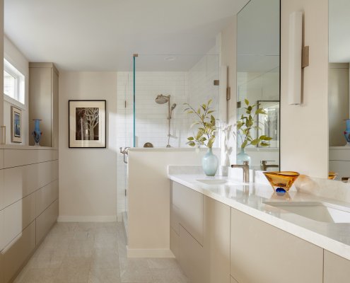 A sleek, neutral bathroom allows colorful artworks to shine in this Los Altos bathroom.