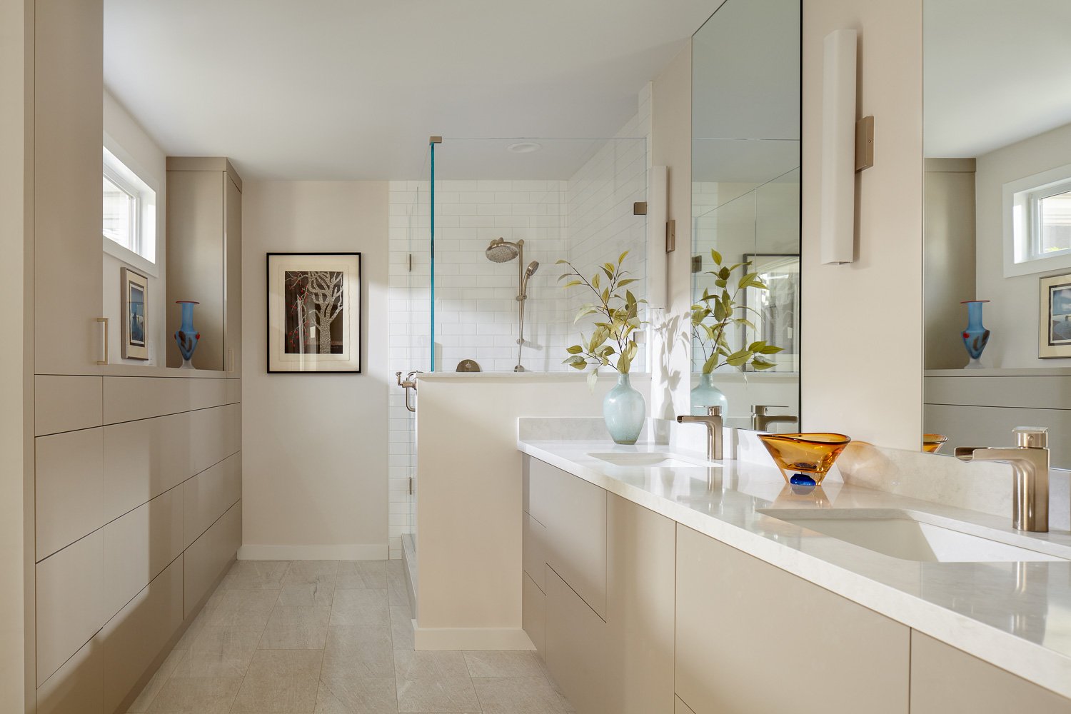 A sleek, neutral bathroom allows colorful artworks to shine in this Los Altos bathroom.