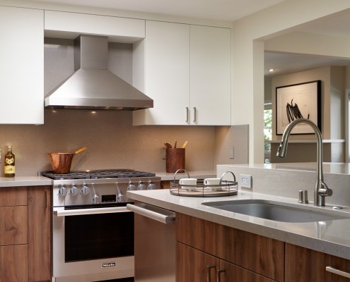 A modern kitchen island is home to both a sink and dishwasher. An elevated bar offers room for casual dining.