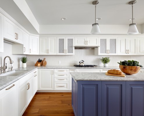 A Los Gatos kitchen features bright white cabinetry and a blue island with some artful finishes.