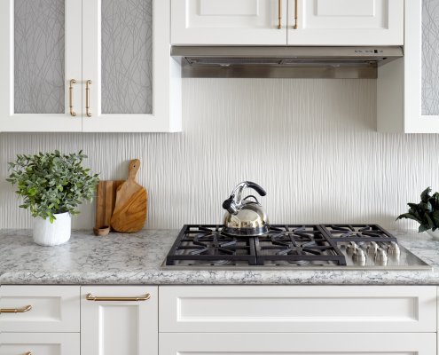 This Los Gatos kitchen's finishes include artful cabinet doors and a textural backsplash.
