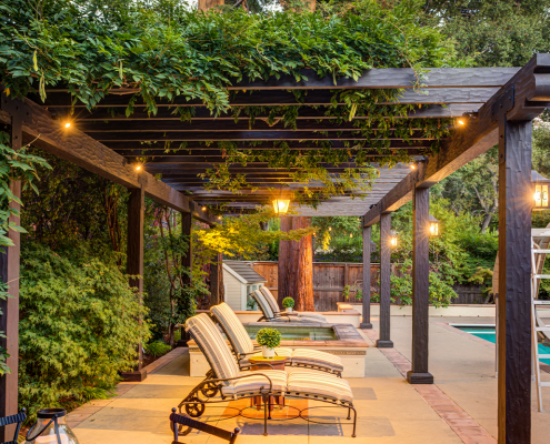 Lounge chairs below a lit pergola