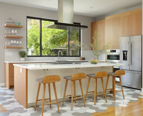 A modern kitchen in San Jose with geometric tile floors and backsplash, wood cabinetry, and stainless steel appliances.