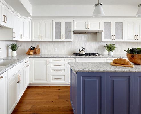 A Los Gatos kitchen features bright white cabinetry and a blue island with some artful finishes.