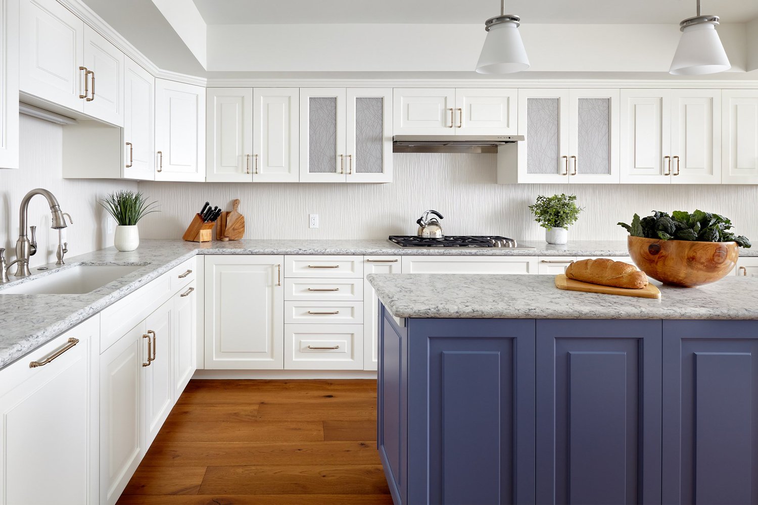 A Los Gatos kitchen features bright white cabinetry and a blue island with some artful finishes.